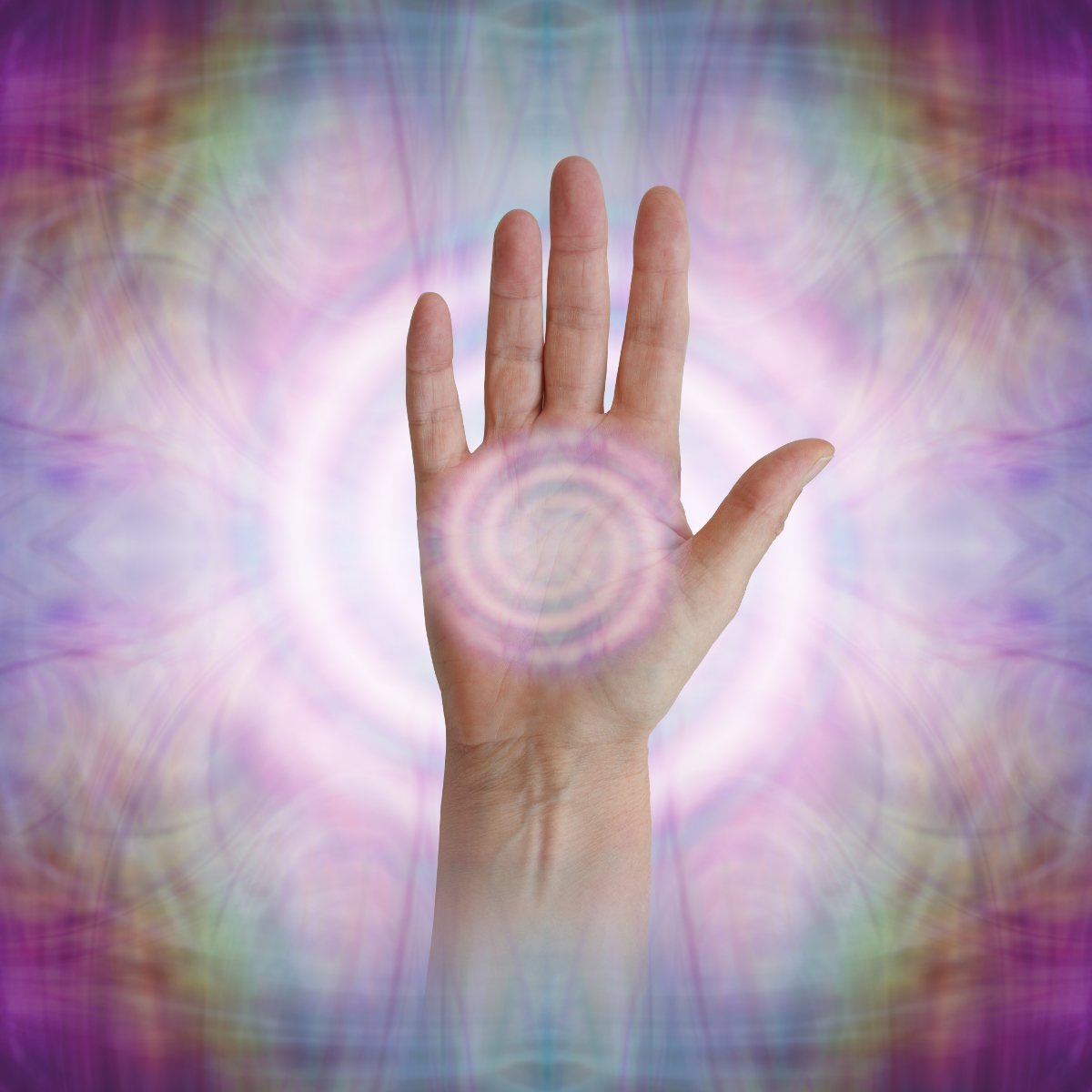 Spiral pattern in the palm of the Reiki master's hand on a multicoloured, abstract background.