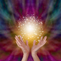Hands held open with a radiant Reiki energy and a colourful, swirling background.