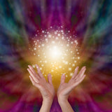 Hands held open with a radiant Reiki energy and a colourful, swirling background.