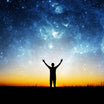 A person's silhouette with arms raised towards a vast, starry sky at sunset, symbolising empowerment and spiritual connection.