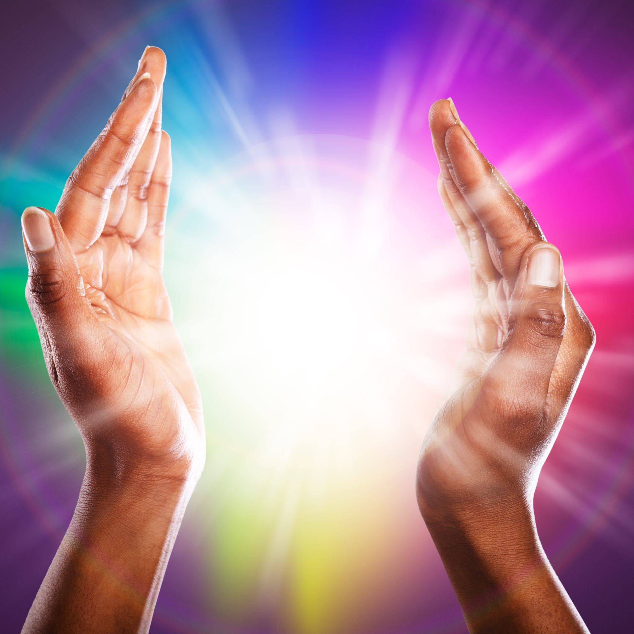 Two hands cupped together, radiating a brilliant white light against a background of rainbow colours, representing energy healers support.