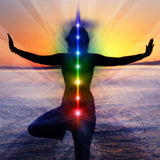 A woman in a yoga tree pose silhouette at sunset with a column of rainbow lights showing kundalini 999 spiritual integration.