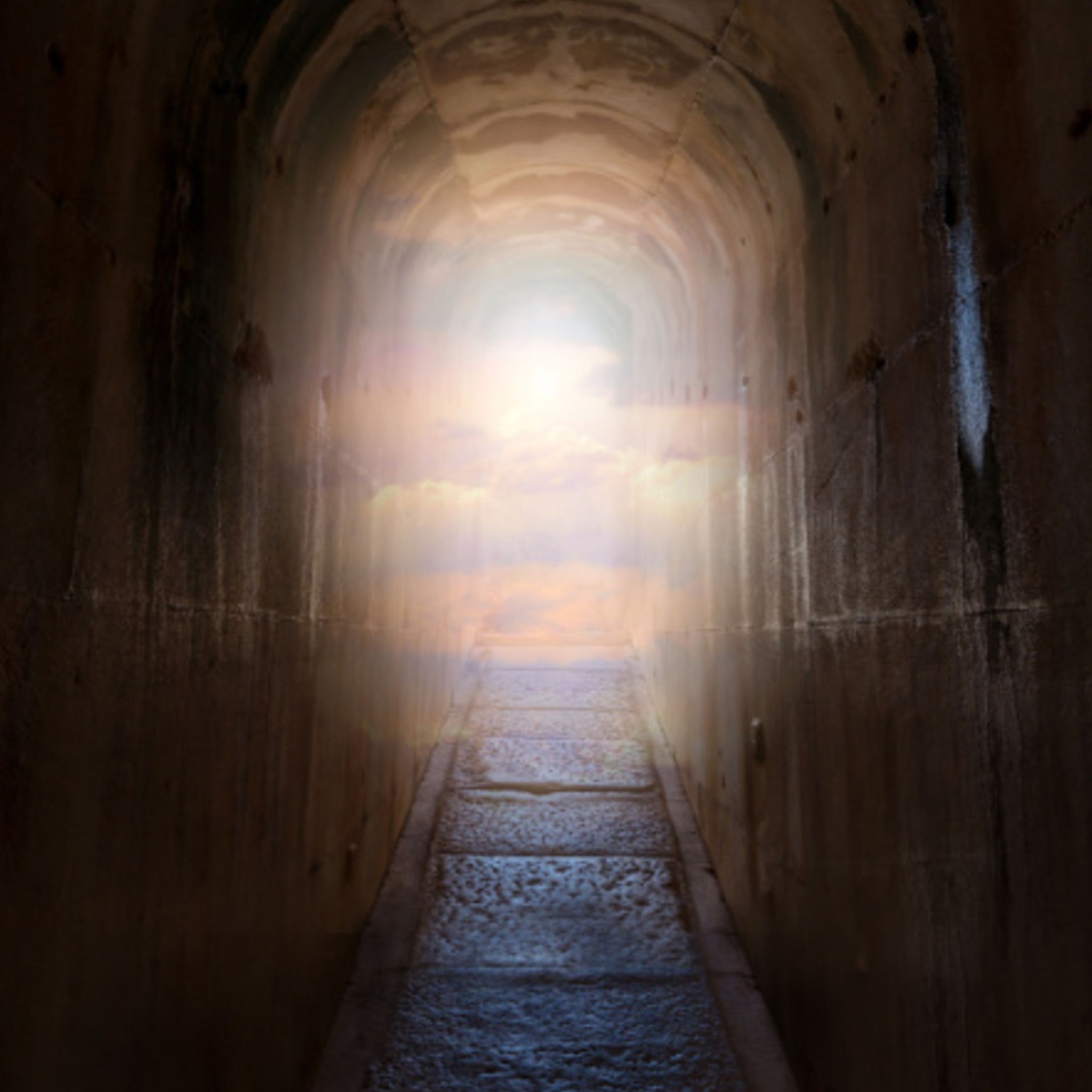 Ultimate Life Path Magic Clearing Treatment: dark stone tunnel leading to a bright light and clouds, symbolising future direction and clarity.