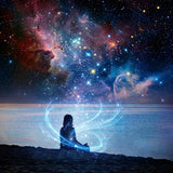 Person sitting on a beach with a cosmic background featuring stars and nebulae.