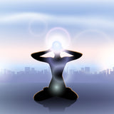 Silhouette meditating above a city, with a glowing third eye light. Suggests life path alignment.